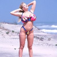 Ash-blonde solo model Kayla Kleevage bares her fake breasts from a swimsuit while at the beach