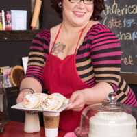 Ginger-haired BBW Kitty McPherson sports short hair and glasses while disrobing in an eatery