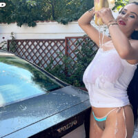 Long-limbed black-haired chick Helen Star lets out her enormous tits while getting moist during a car wash