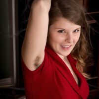 Inked amateur unveils her hairy underarms and pubic hair as she takes off a red dress