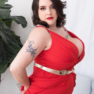 Tattooed BIG SEXY LADY Nagini peels off a red sundress while making her au naturel debut on a couch
